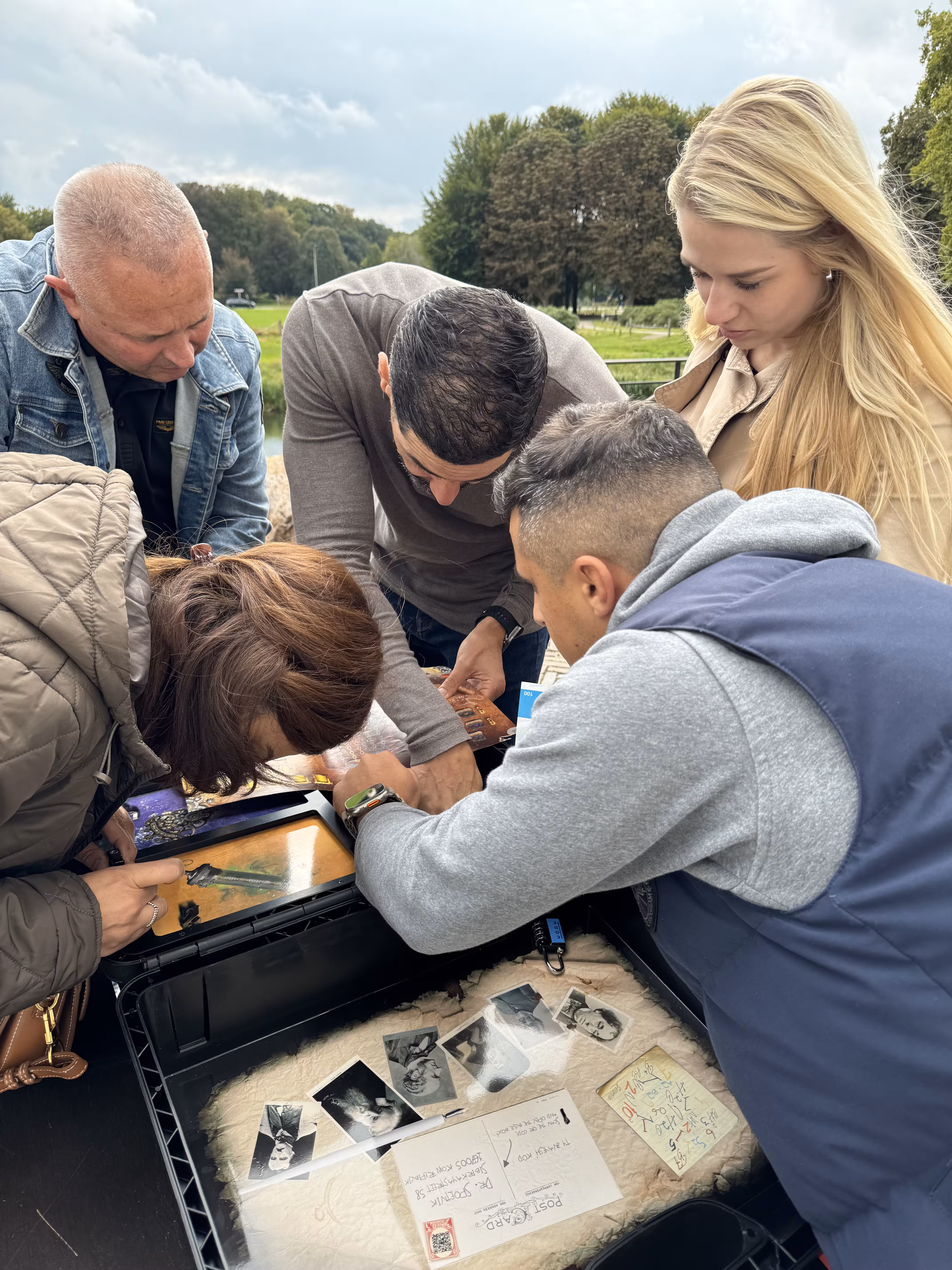 De deelnemers zitten dicht op de escape box om de opdrachten zo goed mogelijk uit te voeren