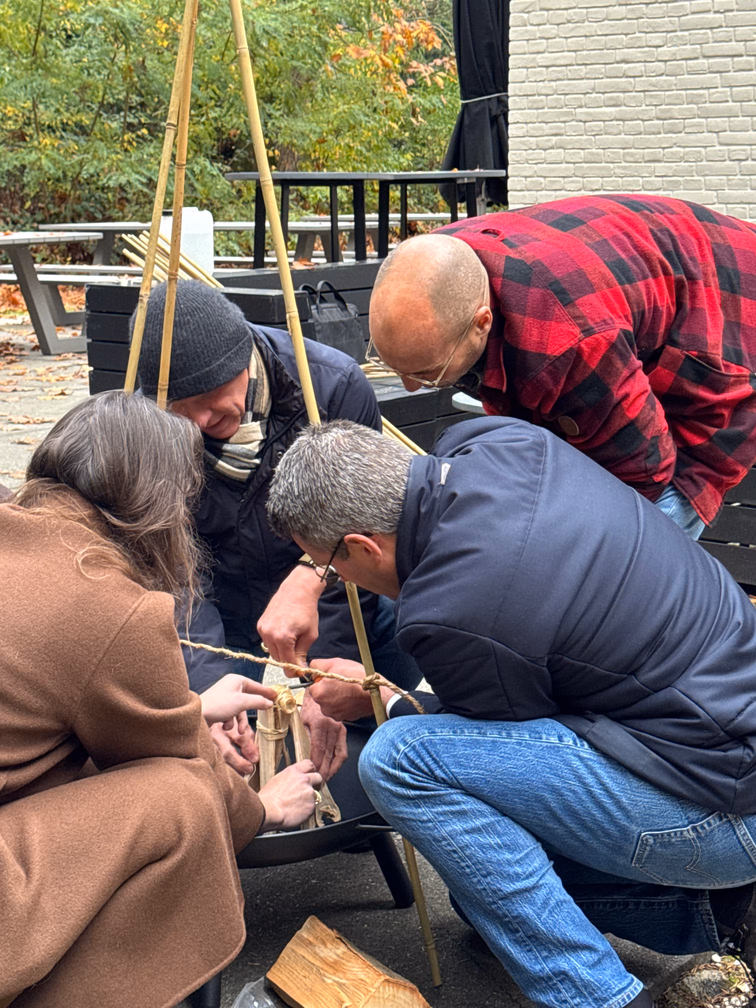 Er wordt in een kleine vuurschaal een constructie van hout gemaakt