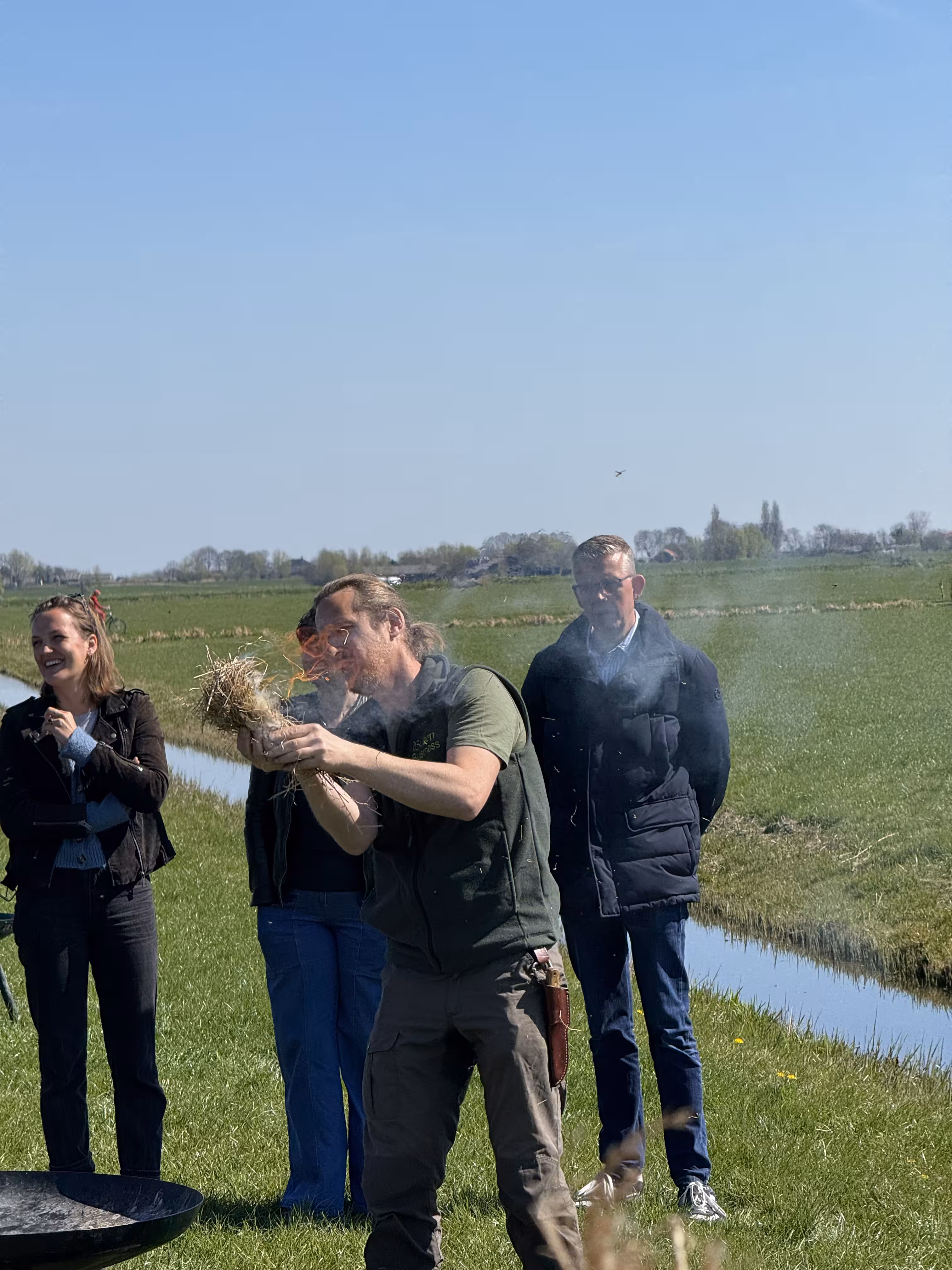 De BuitenEvents instructeur houdt wat brandend hooi vast in zijn handen