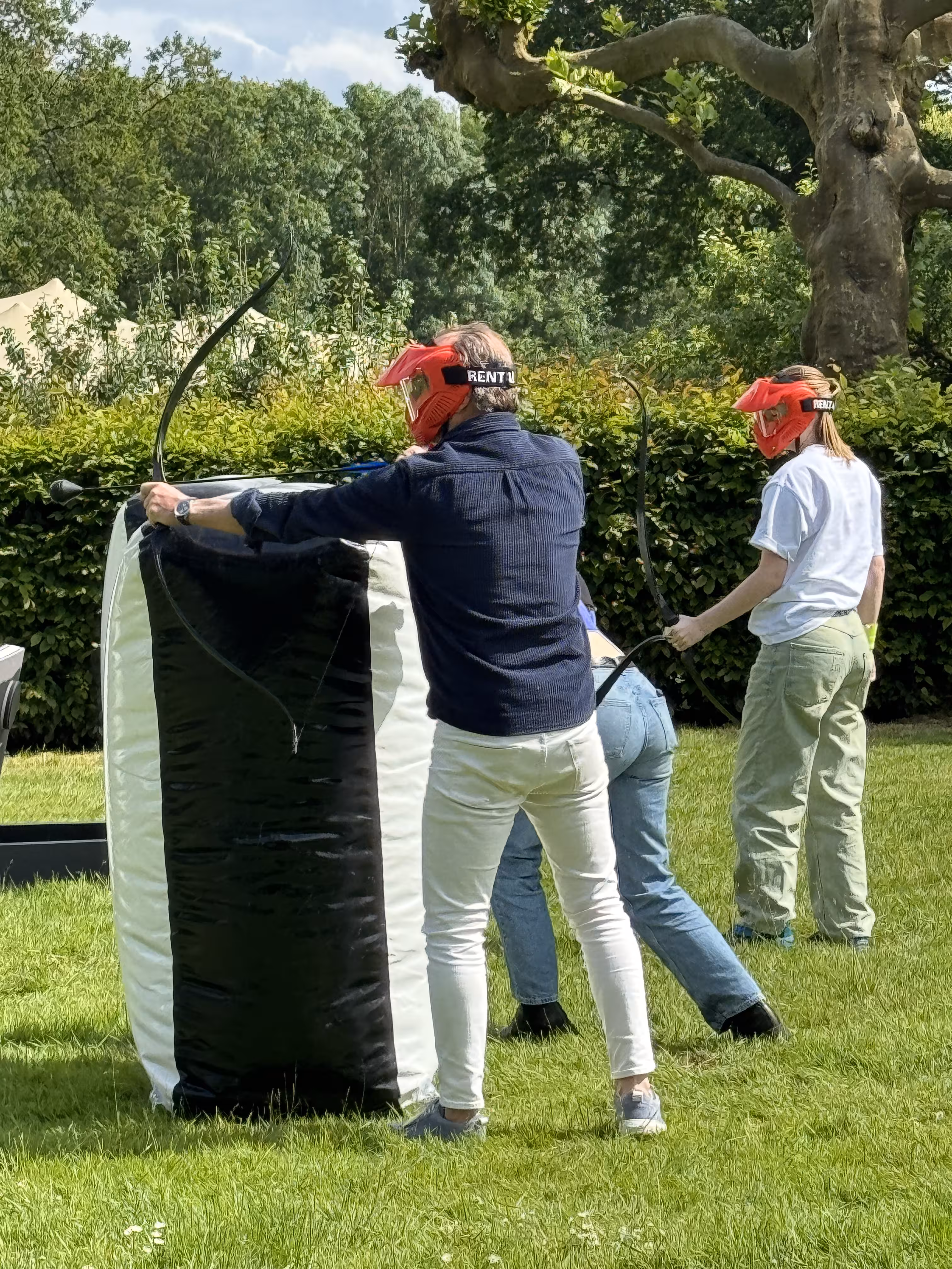 Een deelnemer schiet met pijl en boog en heeft dekking door het opblaas object