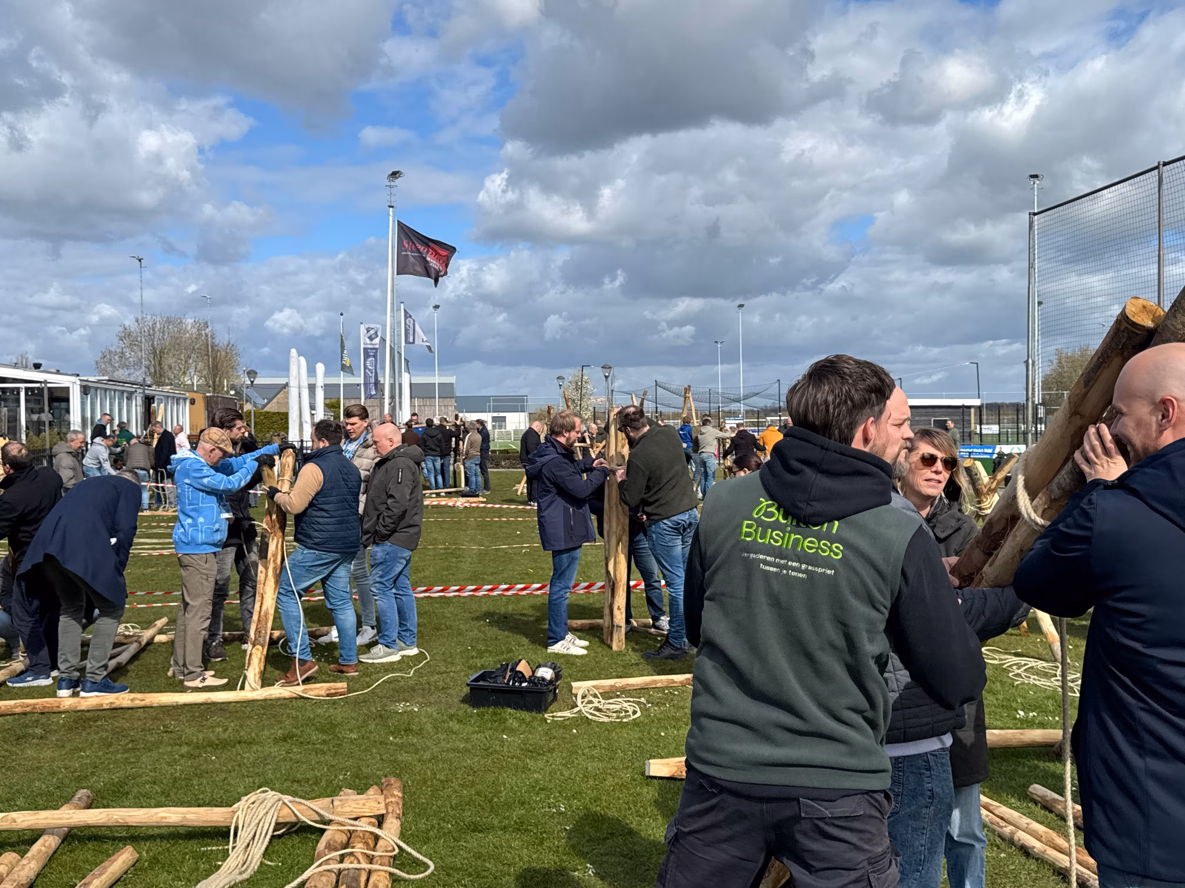 De BuitenEvents instructeur praat met de groep over de voortgang van de katapult die wordt gebouwd