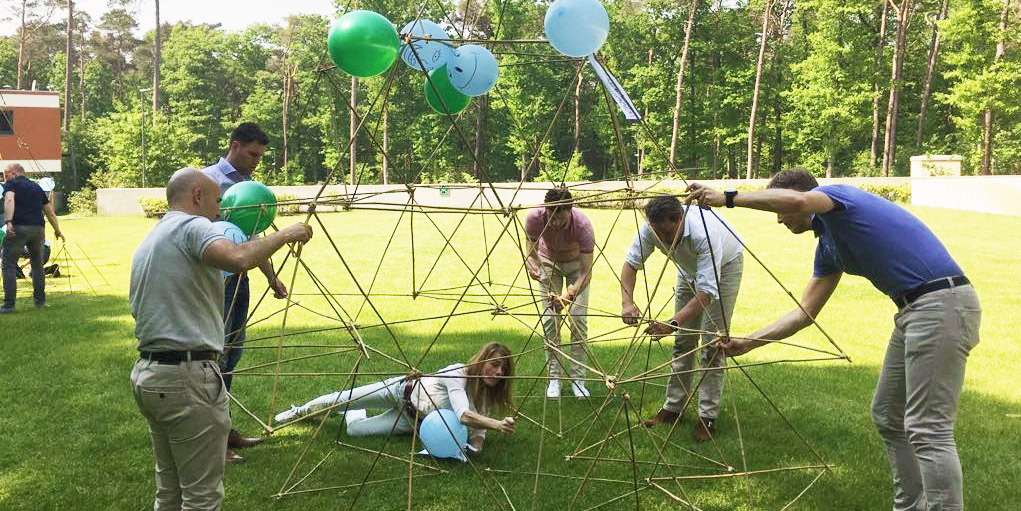 Groep mensen werkt met bamboe tijdens teamspel Alleskunner Teambuilding door BuitenEvents