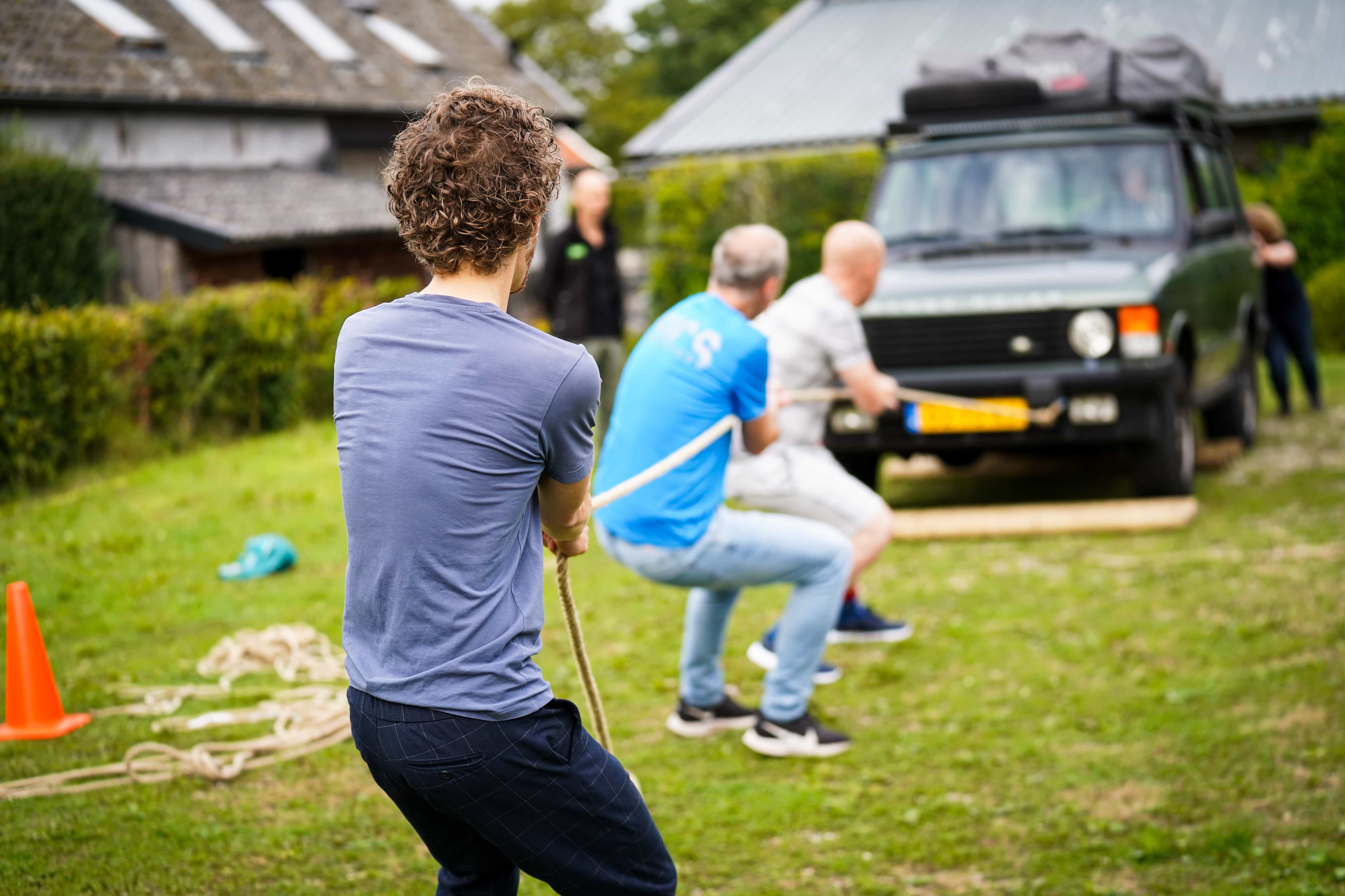 Mensen trekken een Jeep over het parcours tijdens de Alleskunner Teambuilding door BuitenEvents