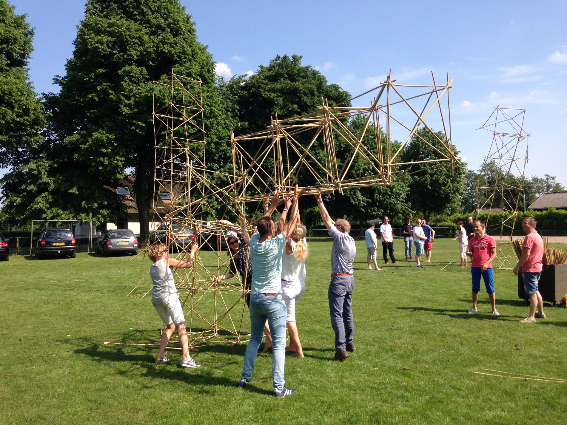 Groep mensen bouwt met bamboe een toren tijdens de Alleskunner Teambuilding door BuitenEvents