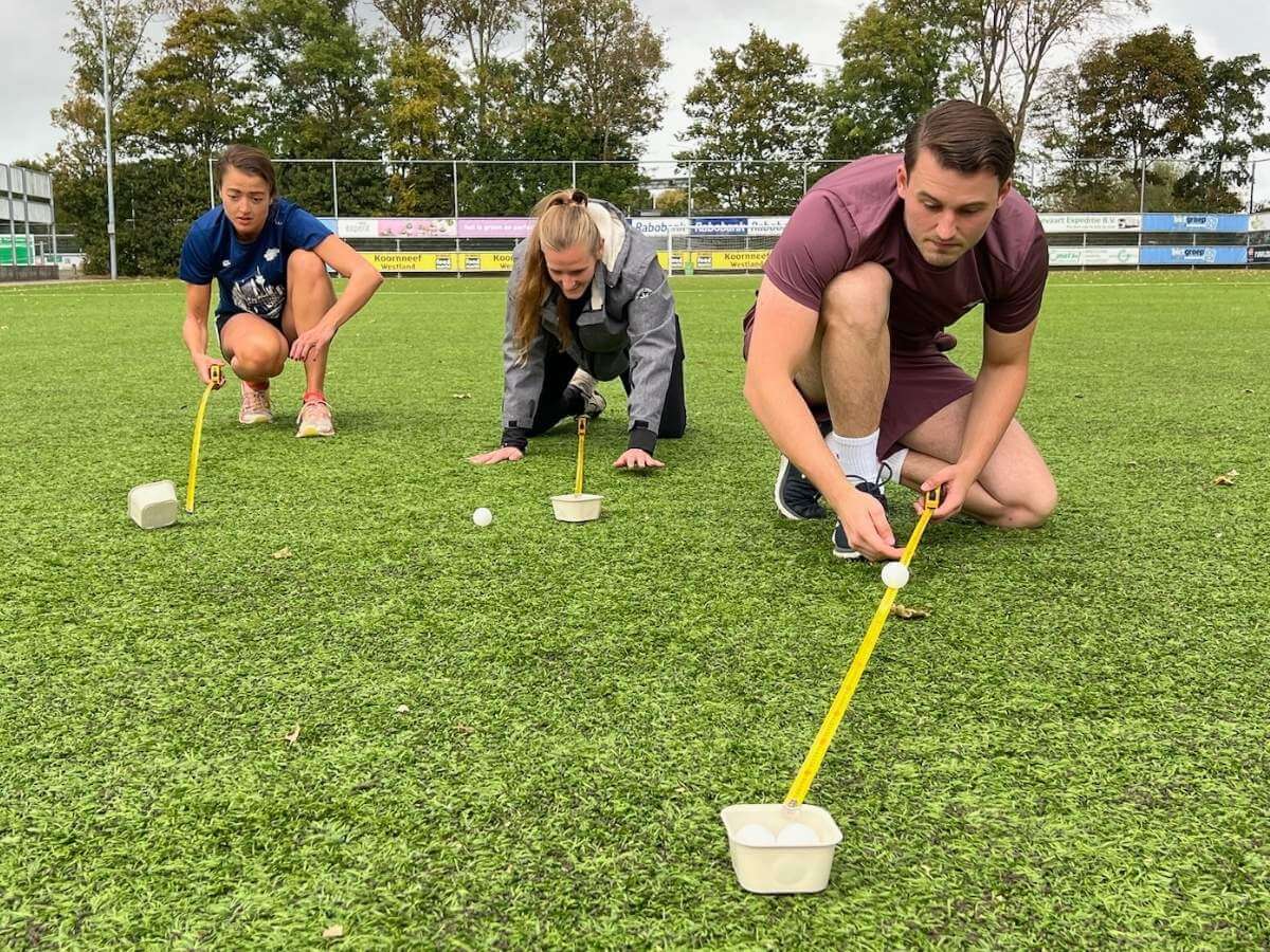 Mensen blazen pingpongbal over meetlint tijdens Alleskunner Teambuilding door BuitenEvents