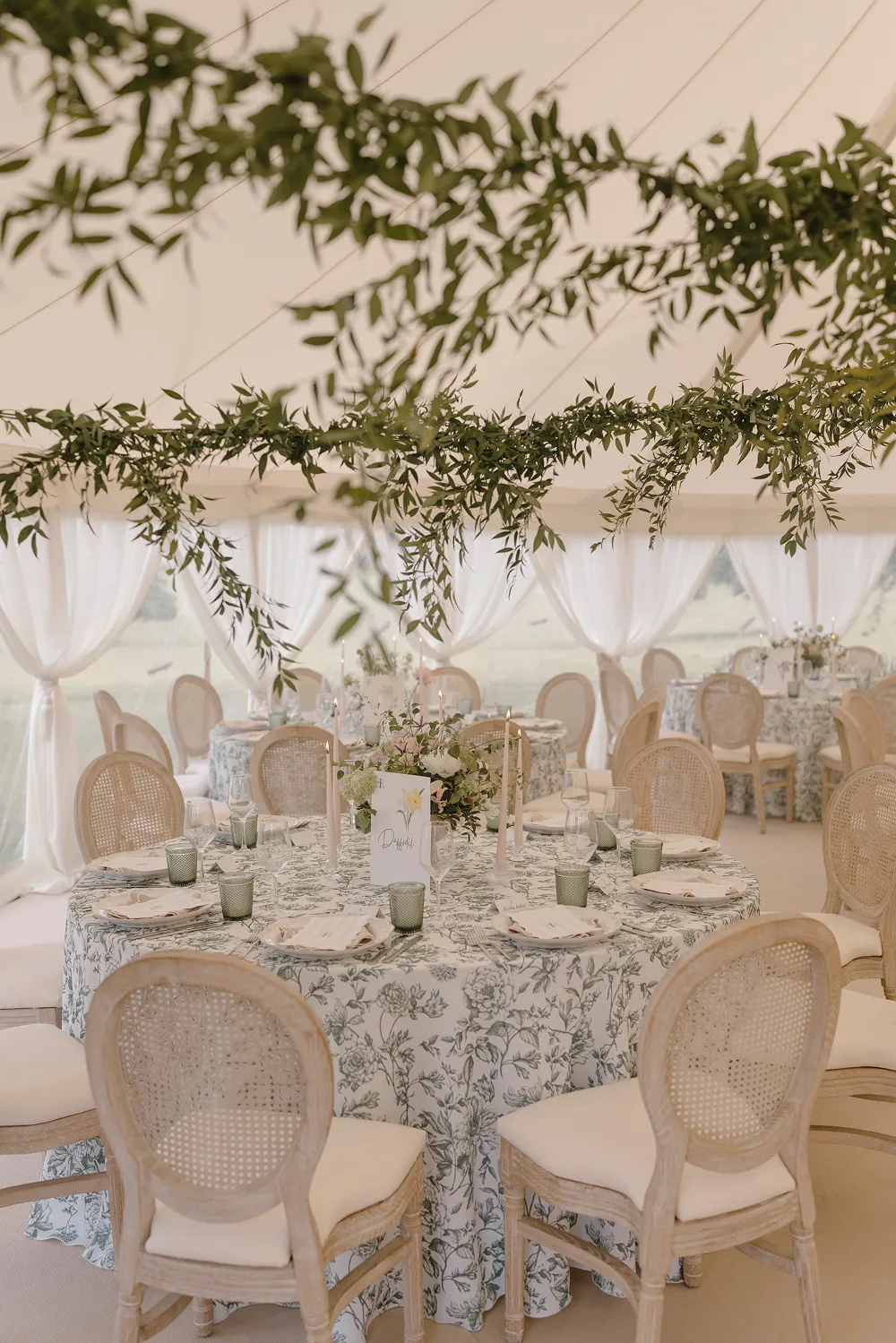 wedding reception table set up with greenery on the marquee roof