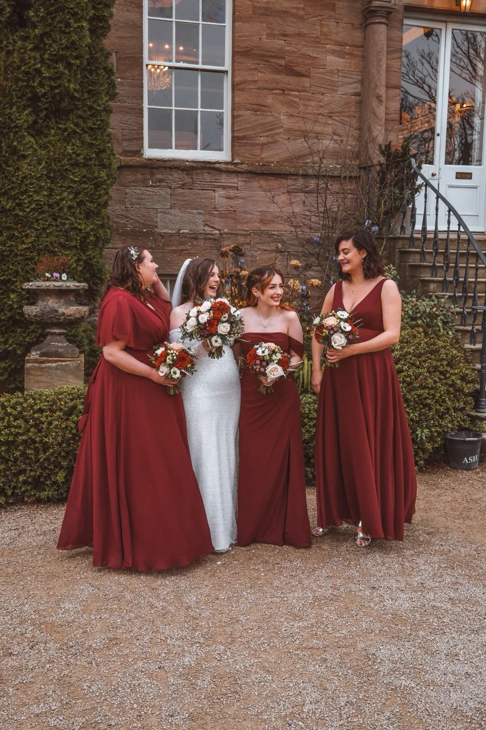 bridesmaids and bride all laughing with matching floral bouquets