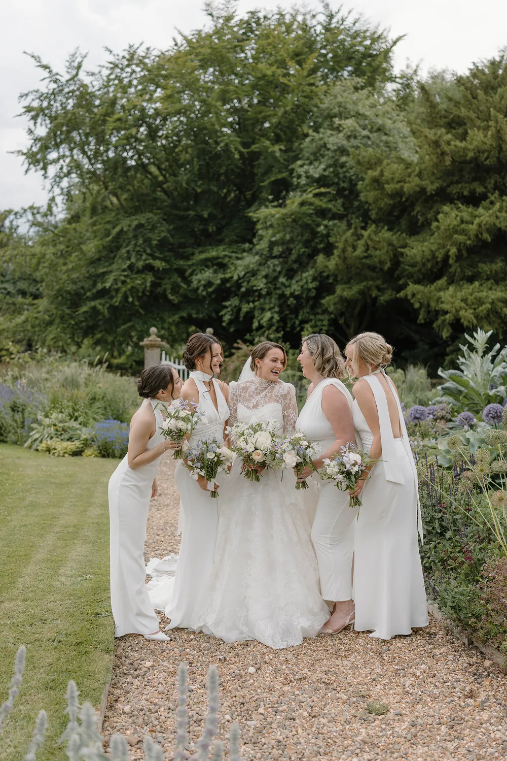 bridesmaids looking at bride with white floral bouquets