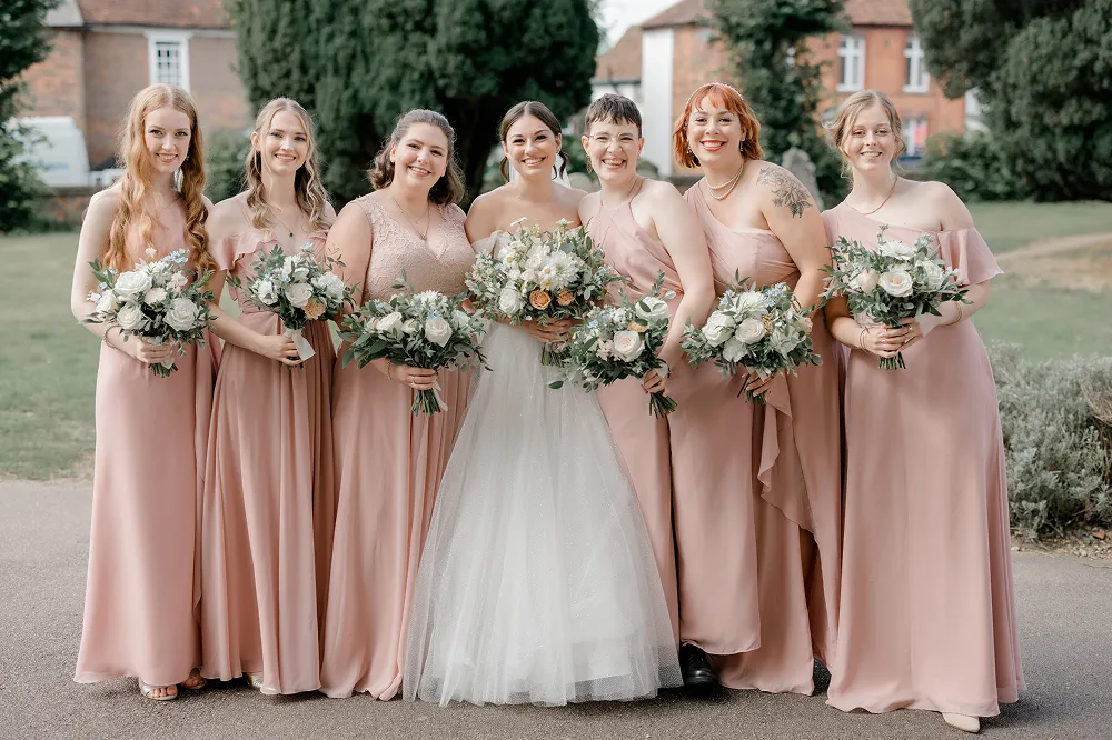 bride and bridesmaids smiling with matching bouquets
