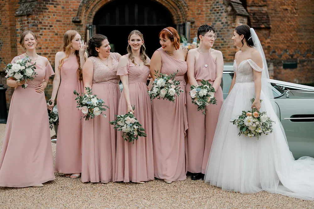 bridesmaids looking at bride with white floral bouquets
