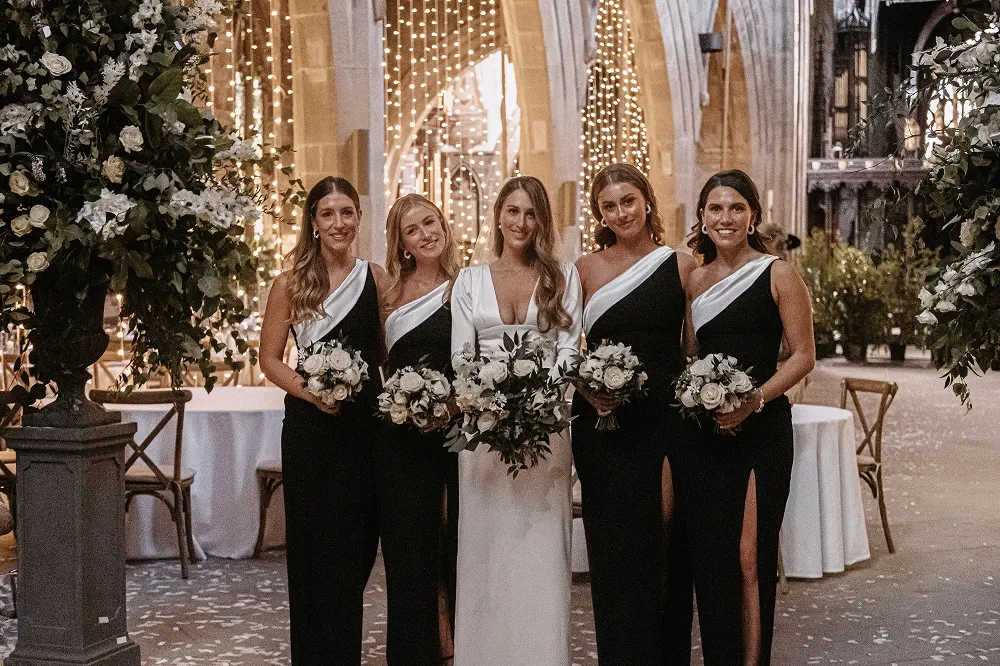 bride and bridesmaids smiling with matching bouquets