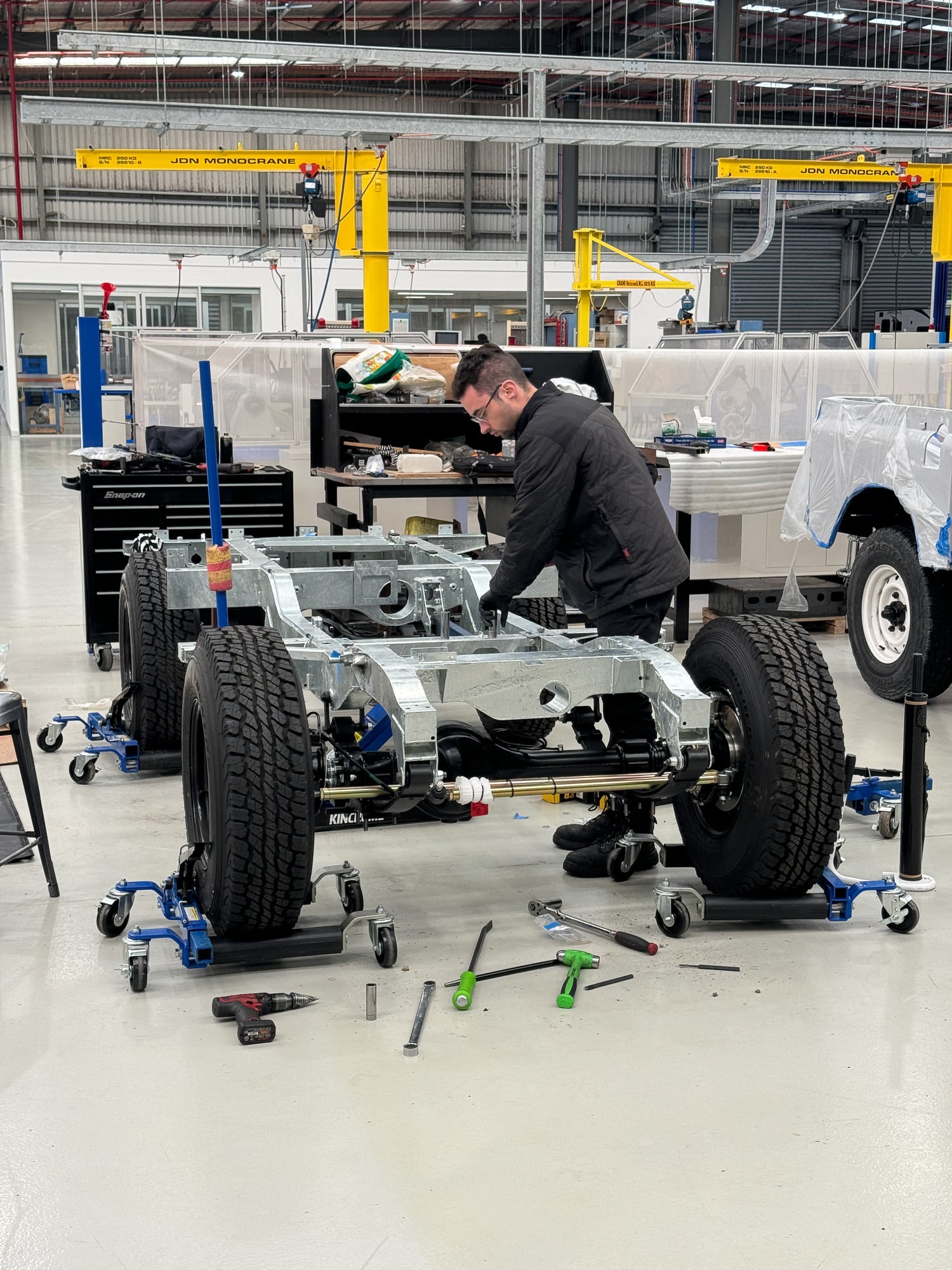 Technician assembling a Jaunt electric Land Rover chassis in the workshop