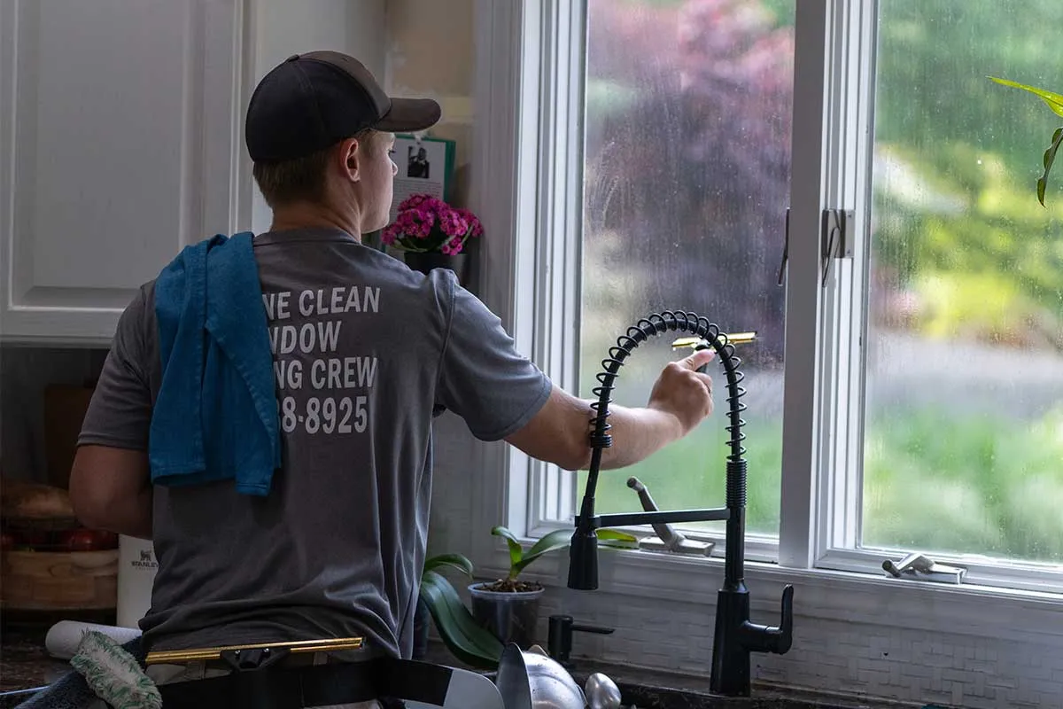 A window cleaning technician with Marine Clean  is cleaning windows.