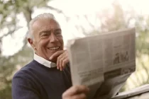 Ein alter Mann liest Zeitung