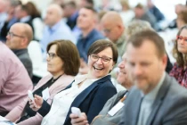 Eine Frau lacht auf einer Konferenz