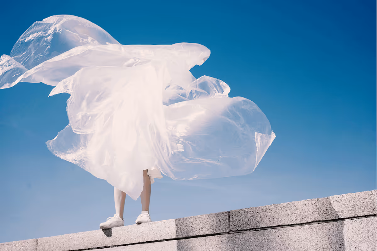 A woman standing outside with flowy fabric.