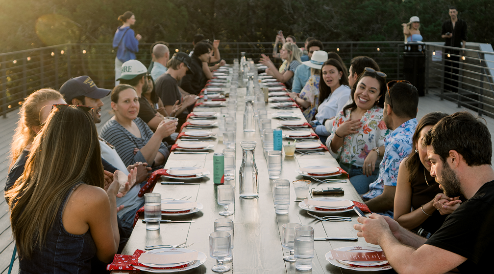 Panel discussion with five people seated on stage against a red backdrop reading 'League of Originals Austin, TX'.