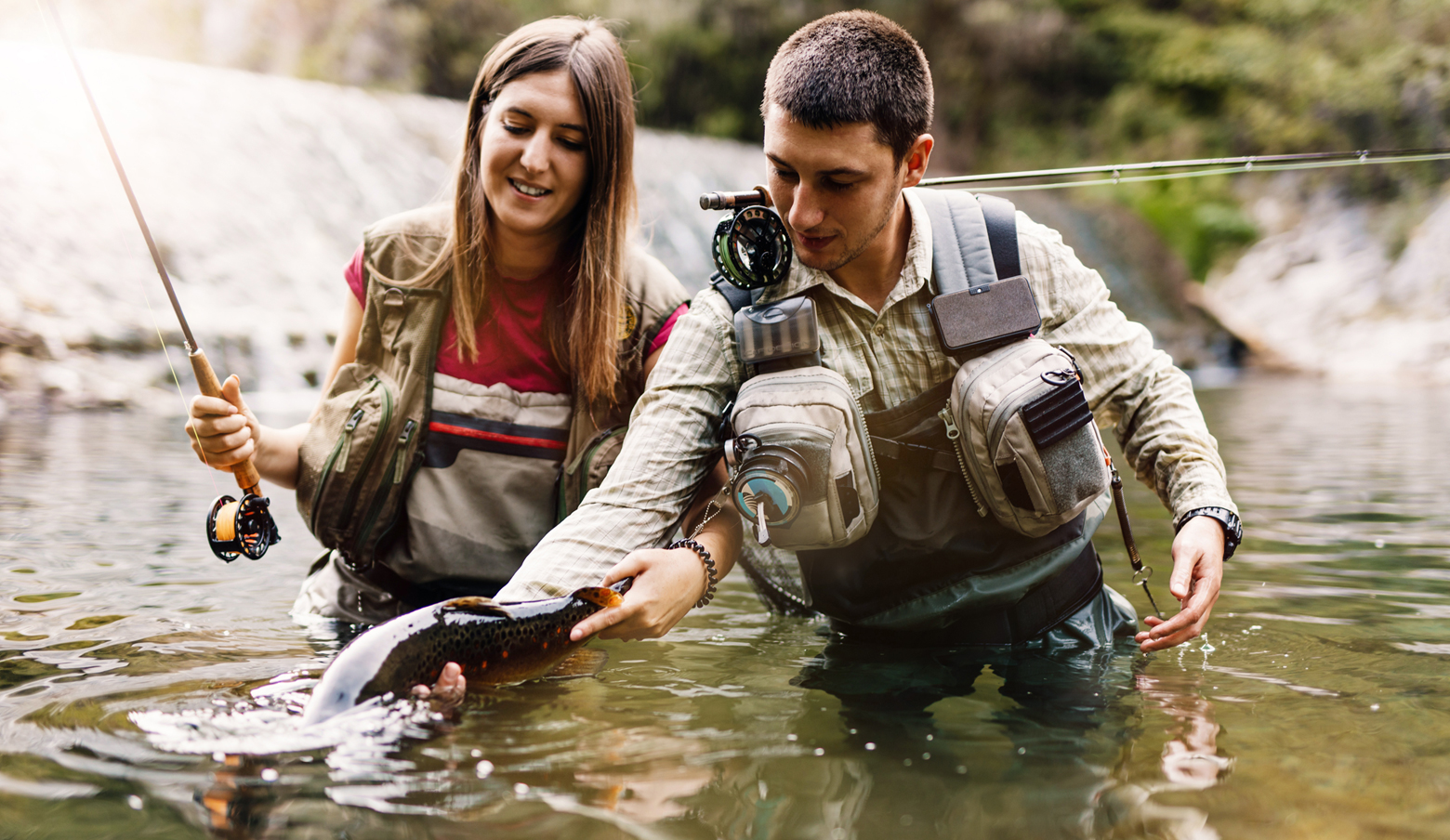 Two people fly fishing in a river