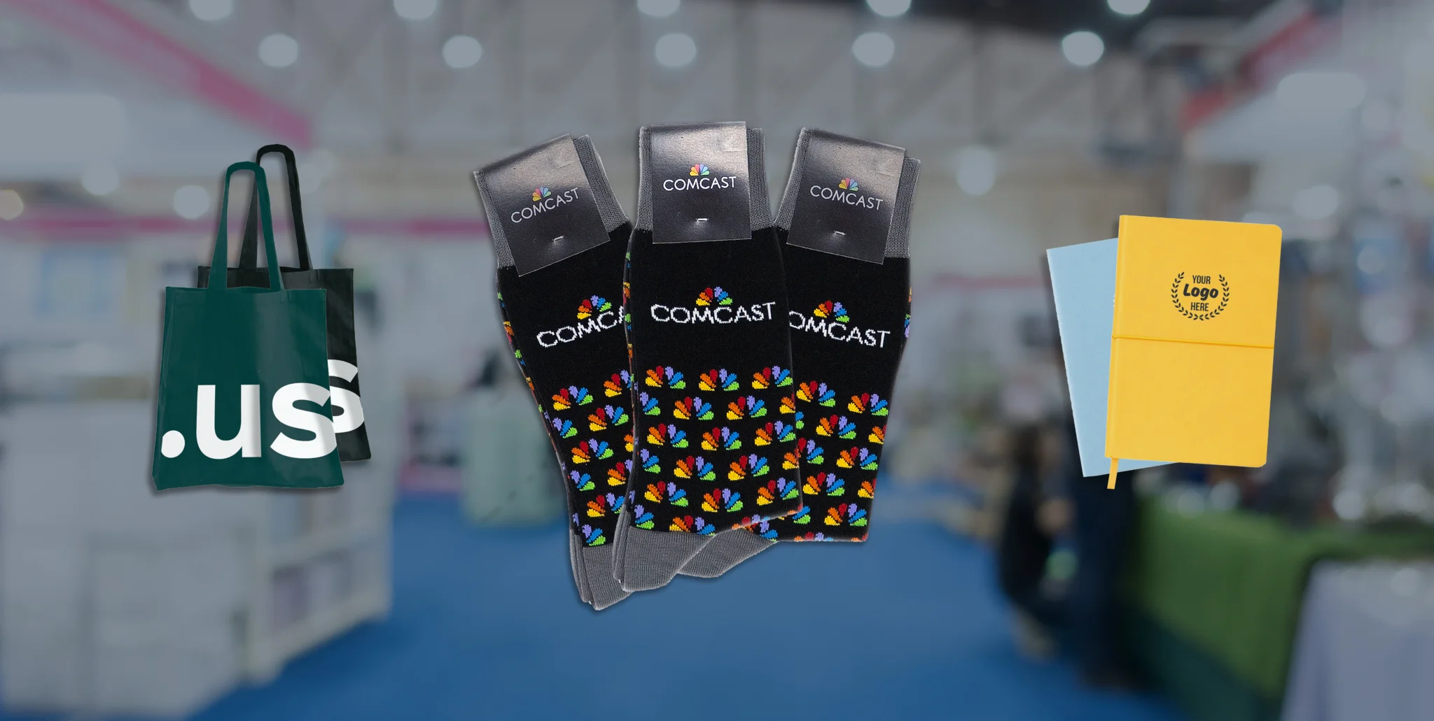 Three examples of swag products displayed. A tote bag, custom socks, and custom notebooks.