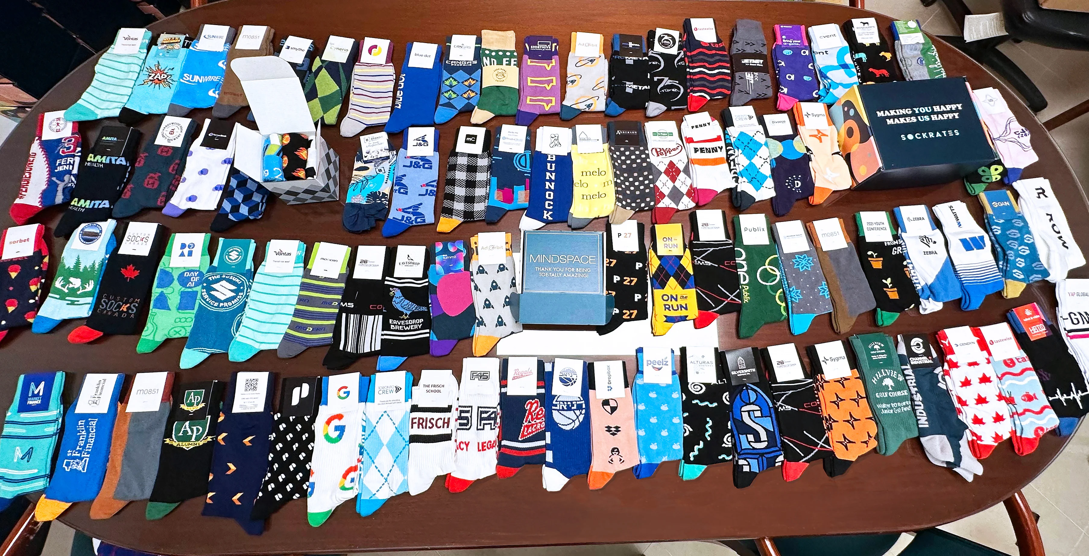 A table full of dozens of custom branded dress socks showcasing the many sock designs available.
