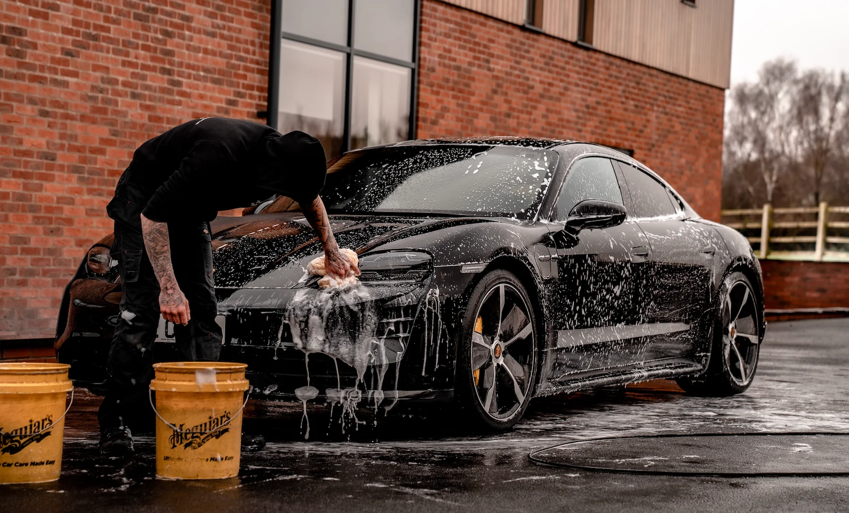 A young man washing cars to raise money for a baseball team