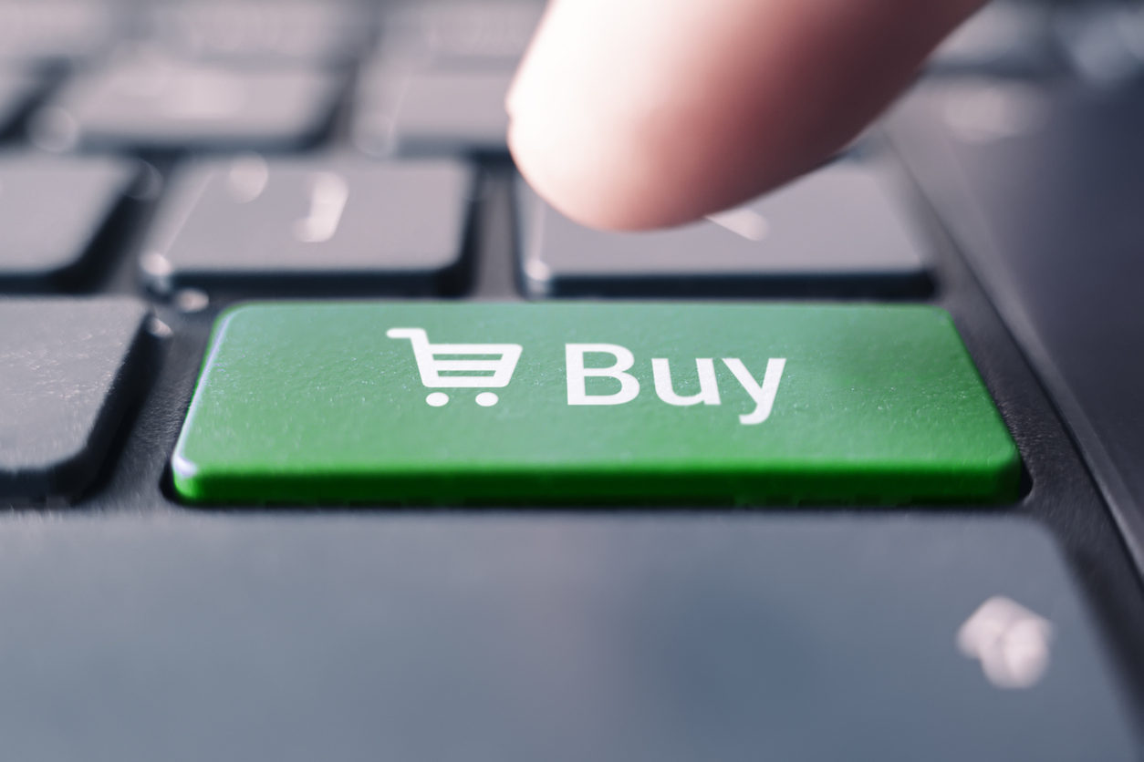 tip of finger getting ready to press green buy button on keyboard