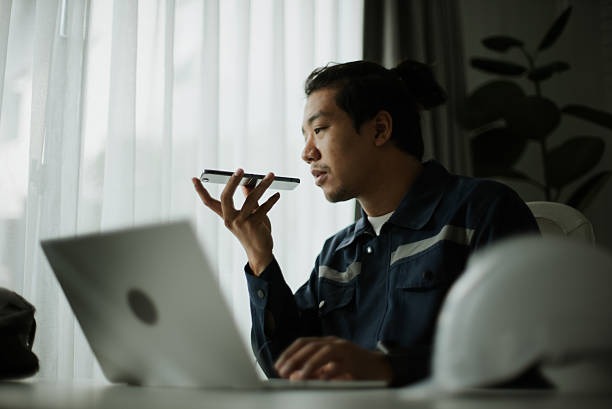 person sitting at a laptop talking on the phone