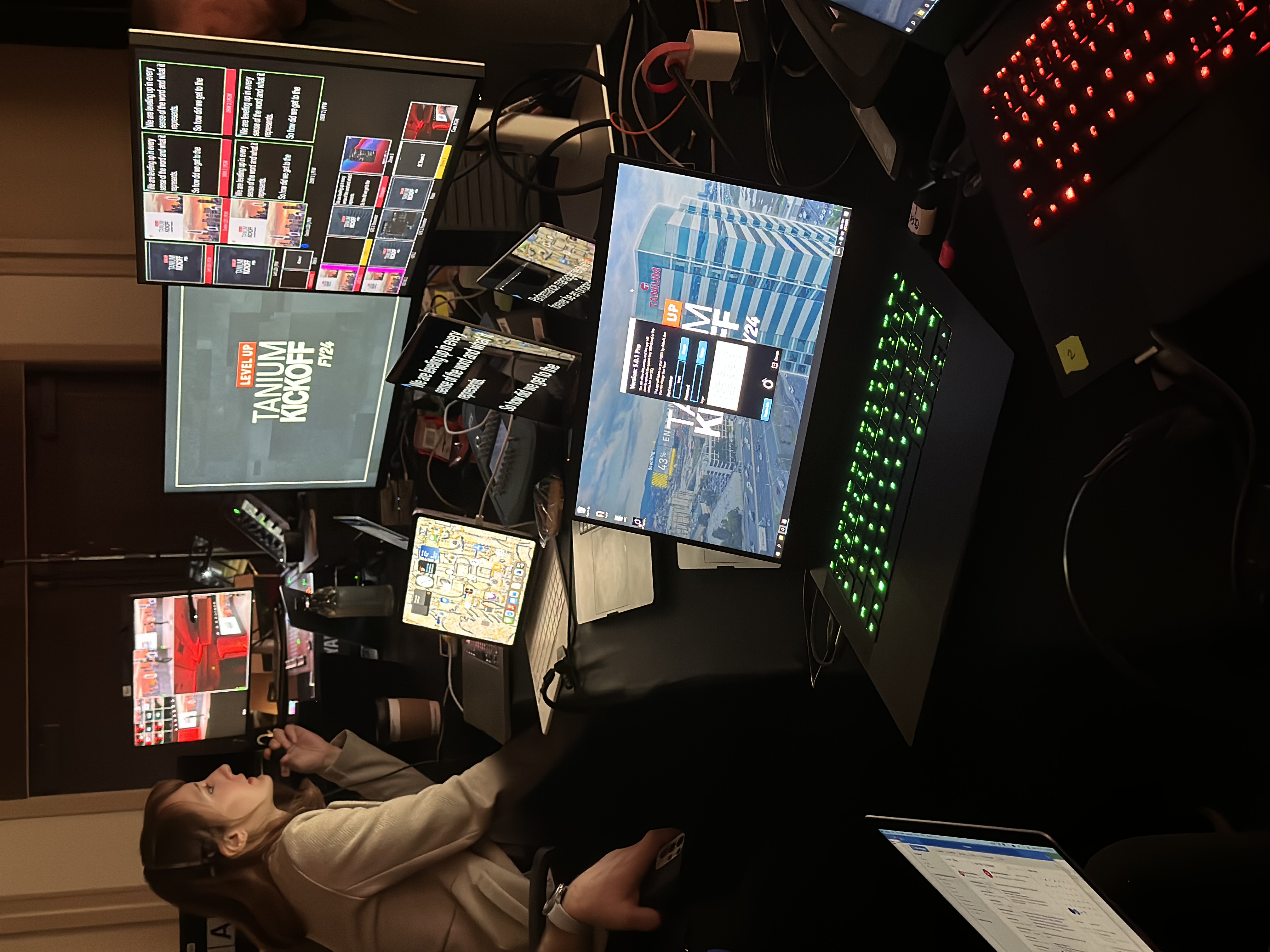Production coordinator overseeing multiple screens and teleprompter feeds backstage