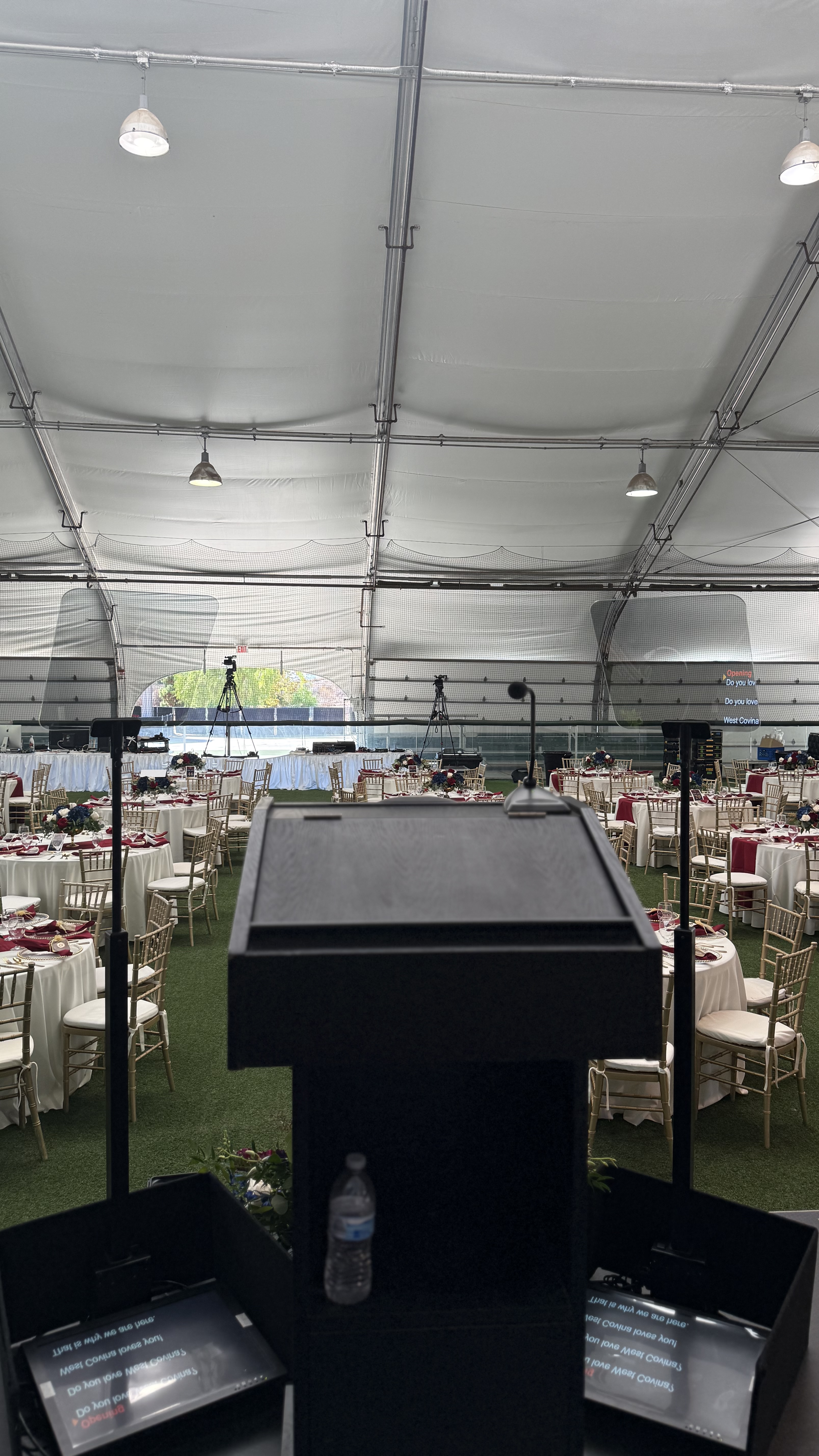 Live event podium setup with large confidence displays positioned for the speaker