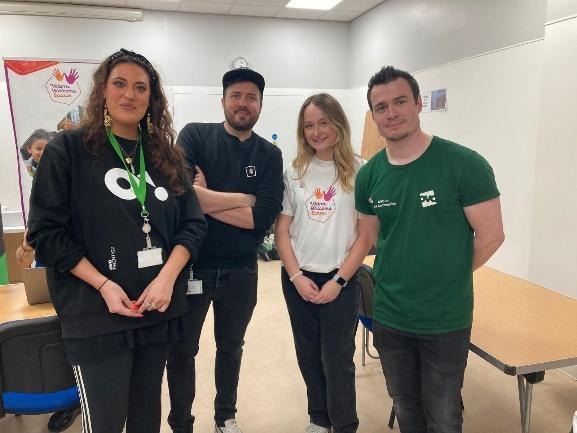 A group of people standing in a roomAI-generated content may be incorrect.