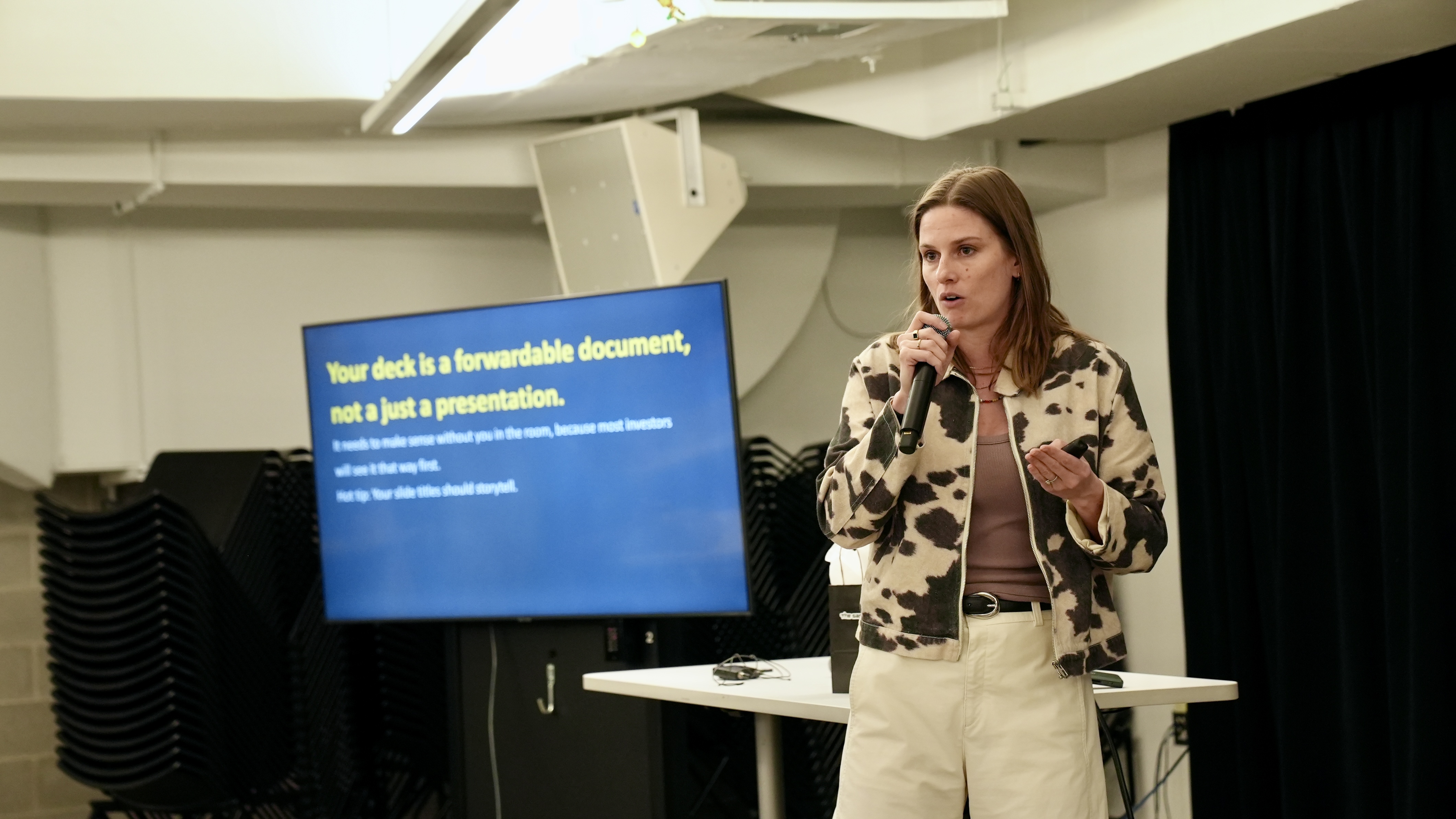 Tina stands with microphone