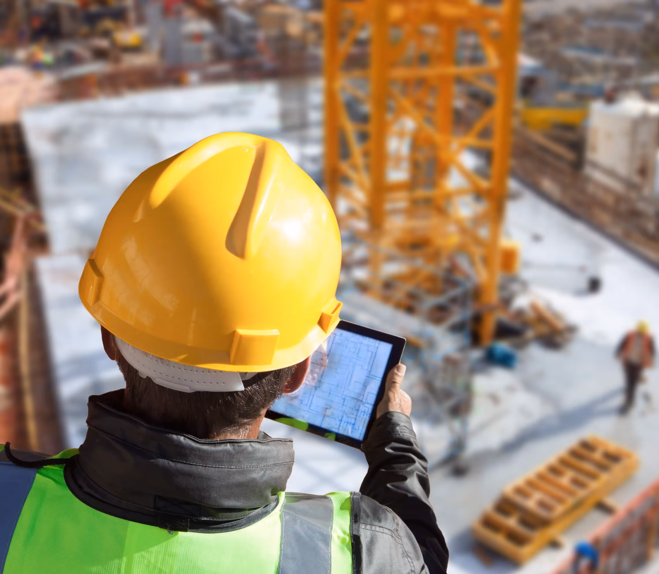Architects on construction site holding tablet using Togal.AI takeoff software to save time and money