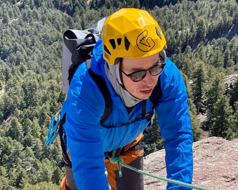 Photo of man finishing a rock climb in Boulder