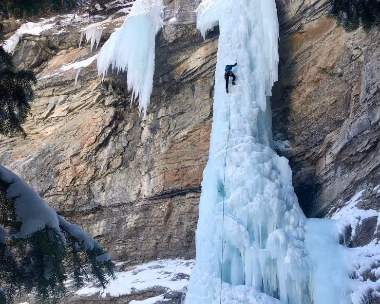 Photo of man climbing a frozen waterfall