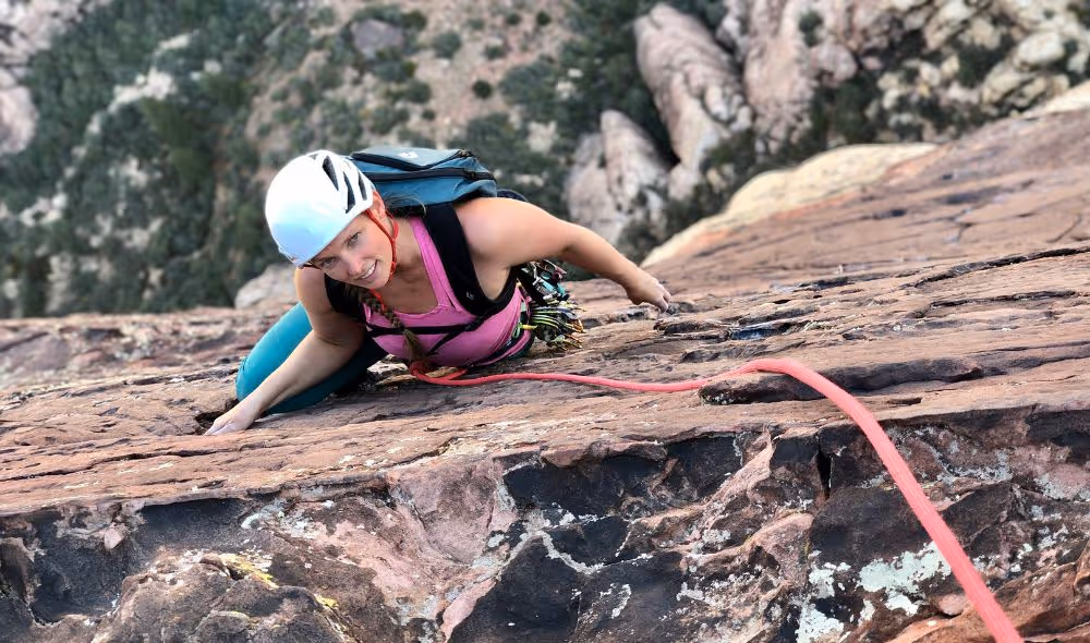 Woman using proper rock climbing technique for safety