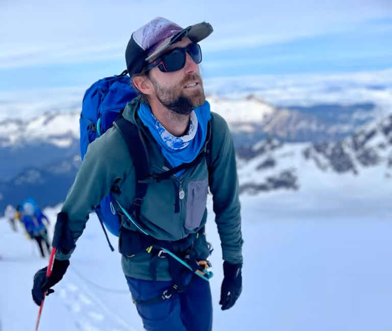 Mountain Guide Ben Markhart leading his team to the snowy summit of Mount Baker.