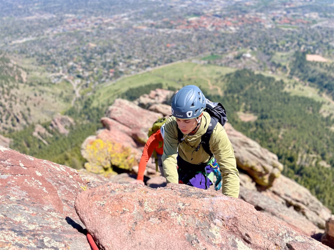 Person at the top of the Boulder Flatirons after finishing a rock climb