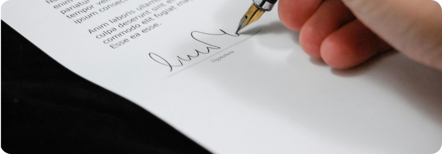 A close-up of someone signing a paper