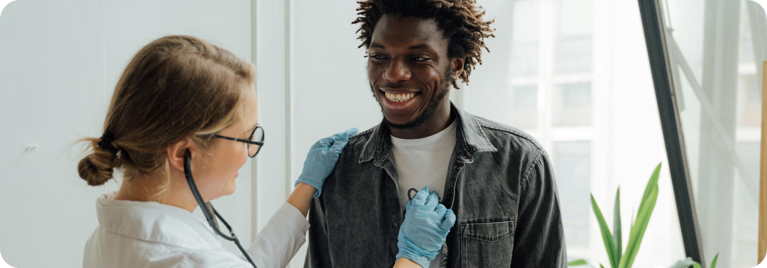 Man smiling as a doctor checks his heartrate