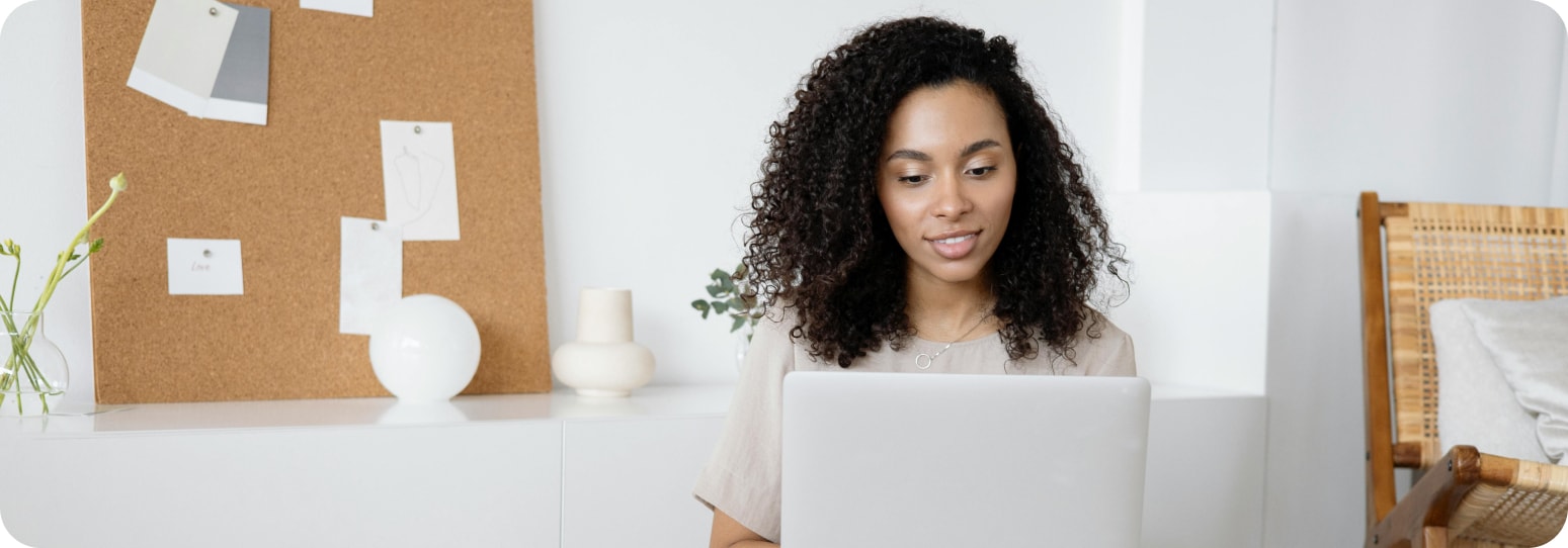 Girl smiling softly as she looks at her laptop