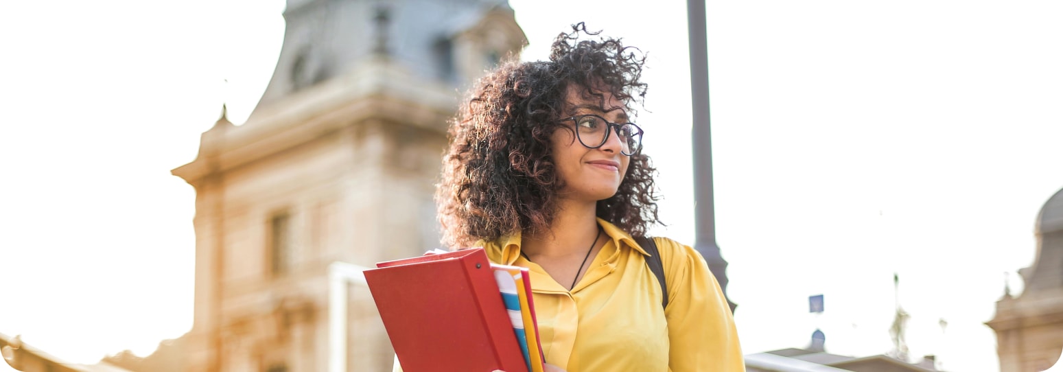 A young woman holding a set of books