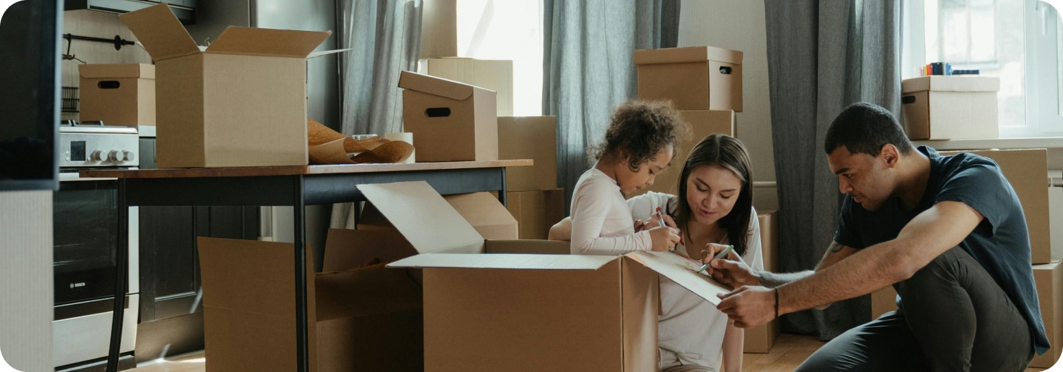 Couple with their child in an apartment full of boxes