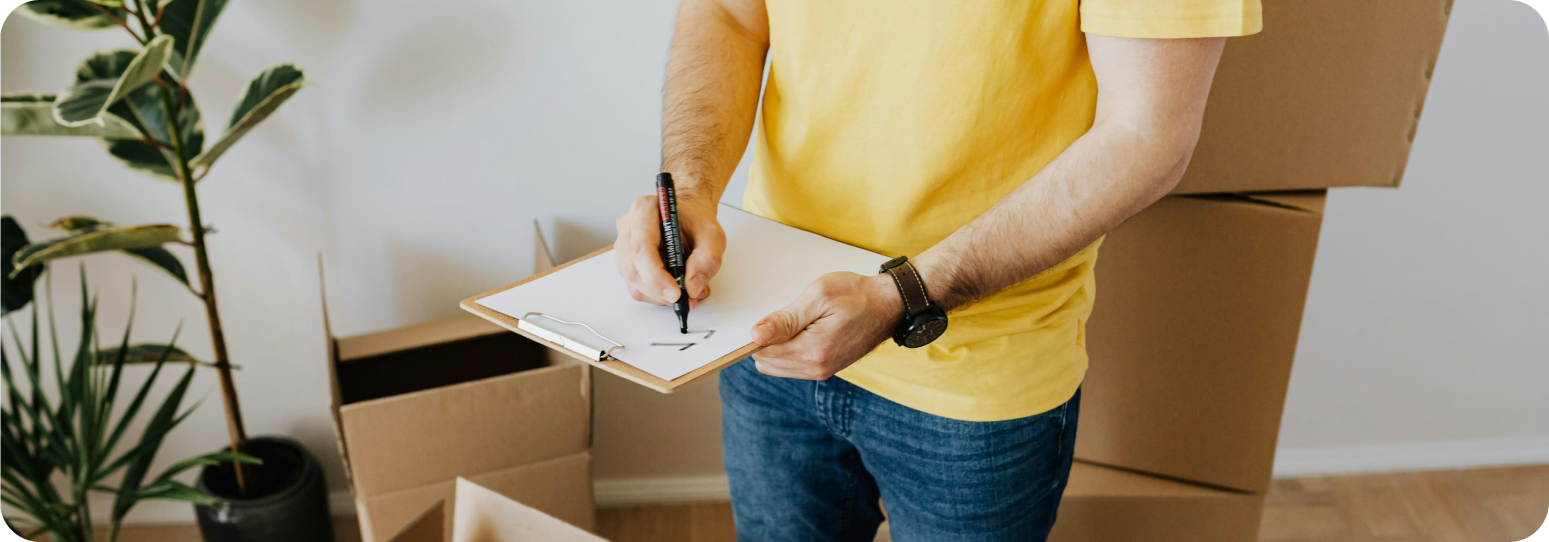 A person in a yellow t-shirt with a checklist and clipboard in hand