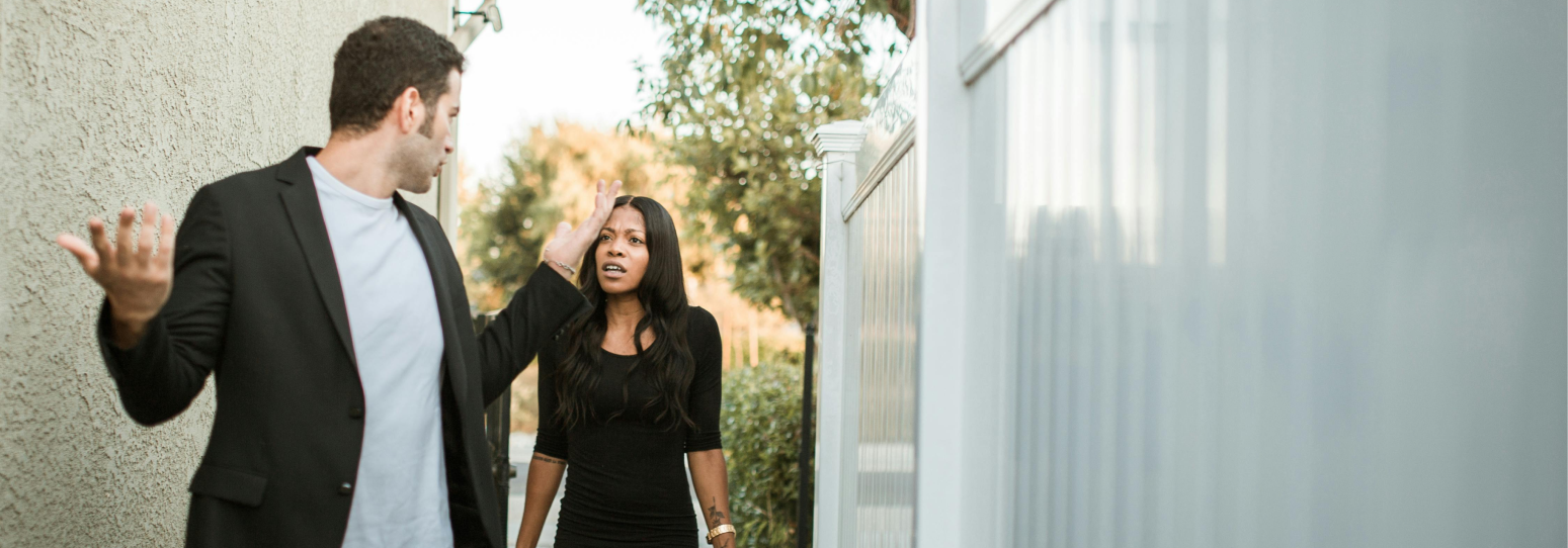 2 people outside in formal attire arguing