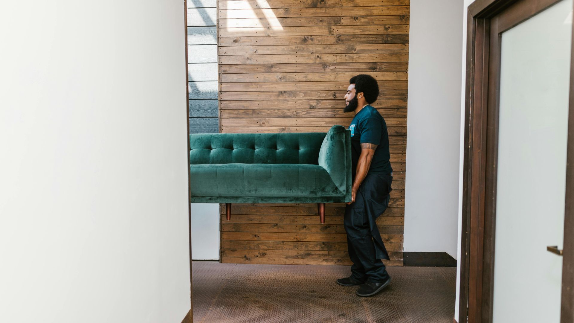 A man moving a couch into an apartment