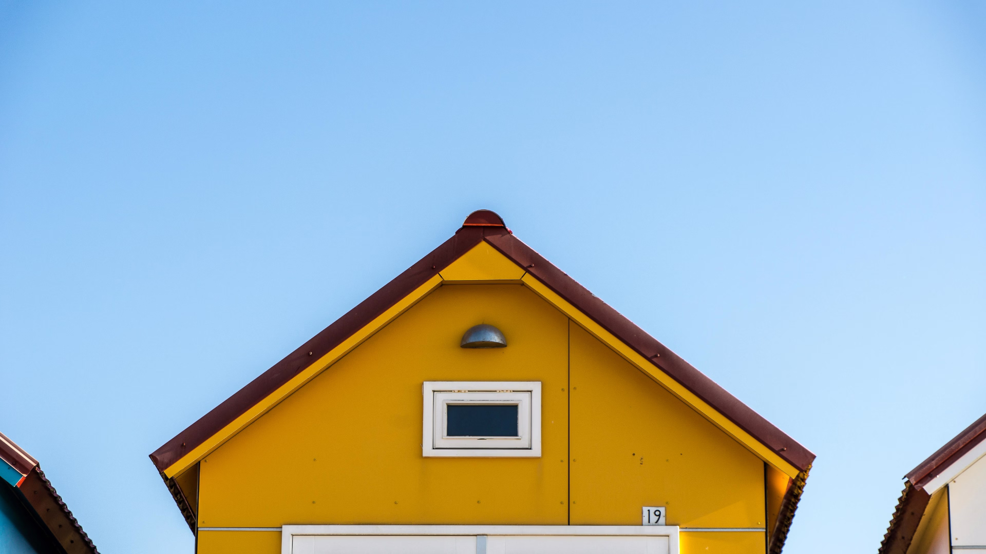 a cut off image of a yellow house, only showing the top half of the house.