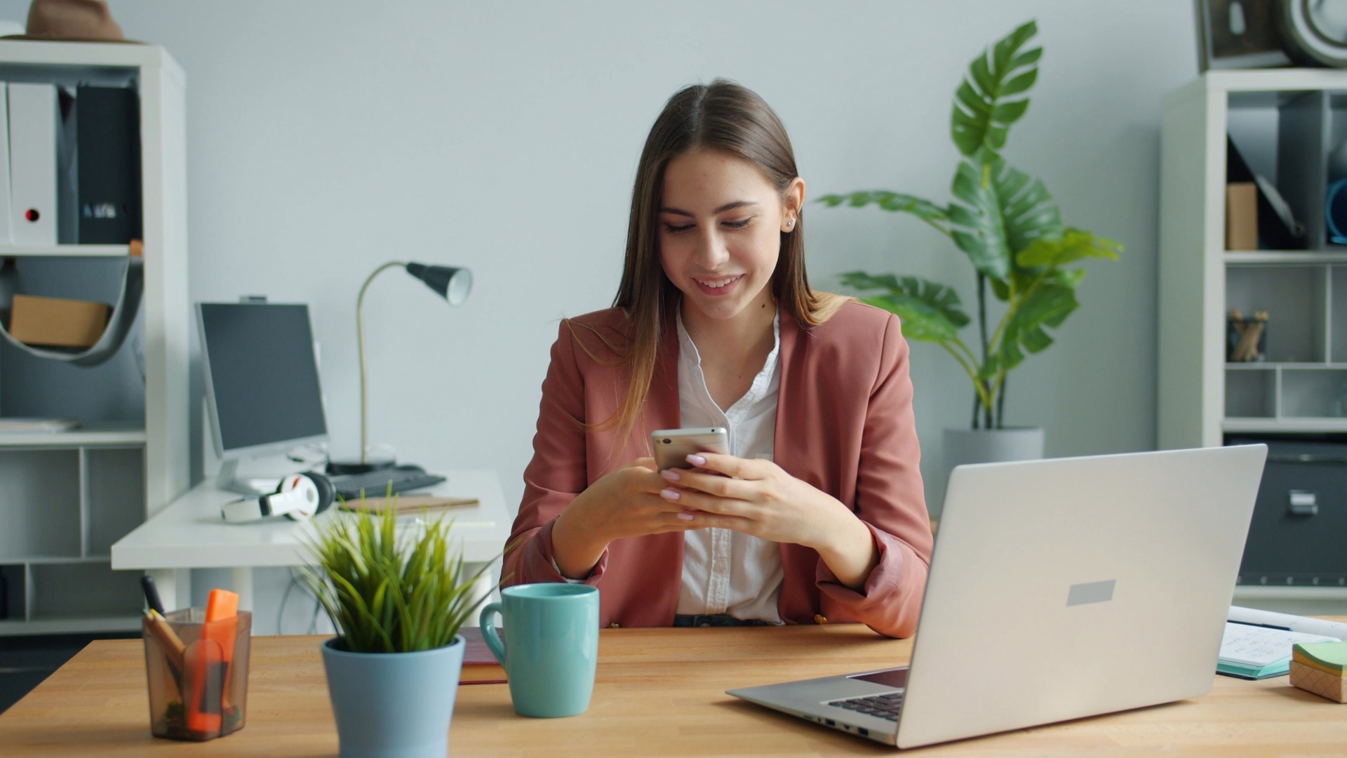 A leasing agent sitting at a desk looking at their phone