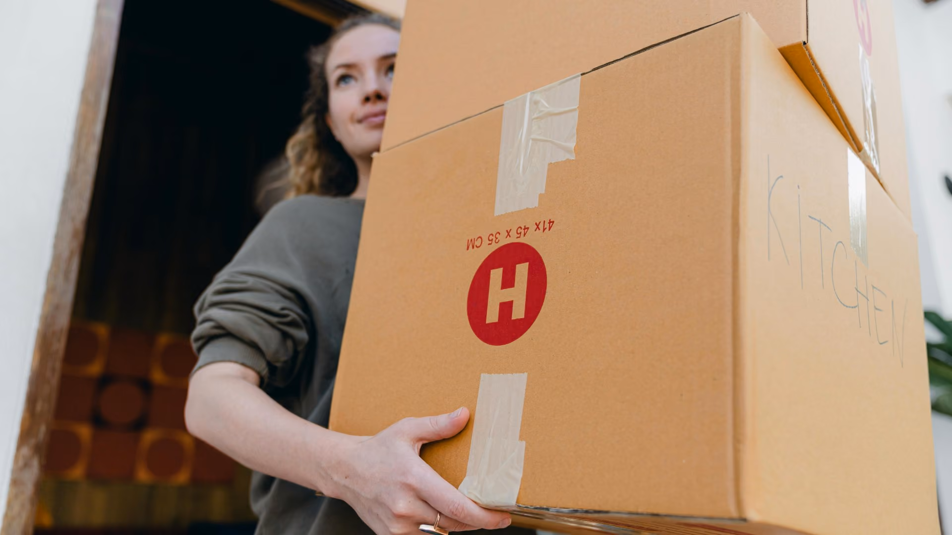 Resident carrying moving boxes into a new apartment during move-in.