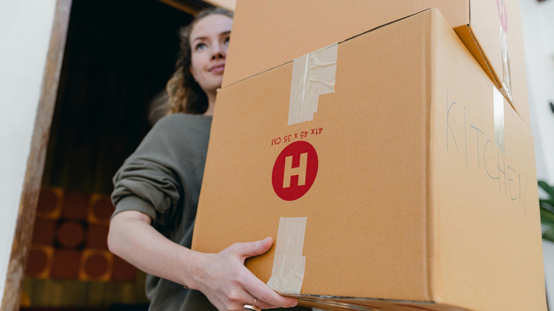 Resident carrying moving boxes into a new apartment during move-in.