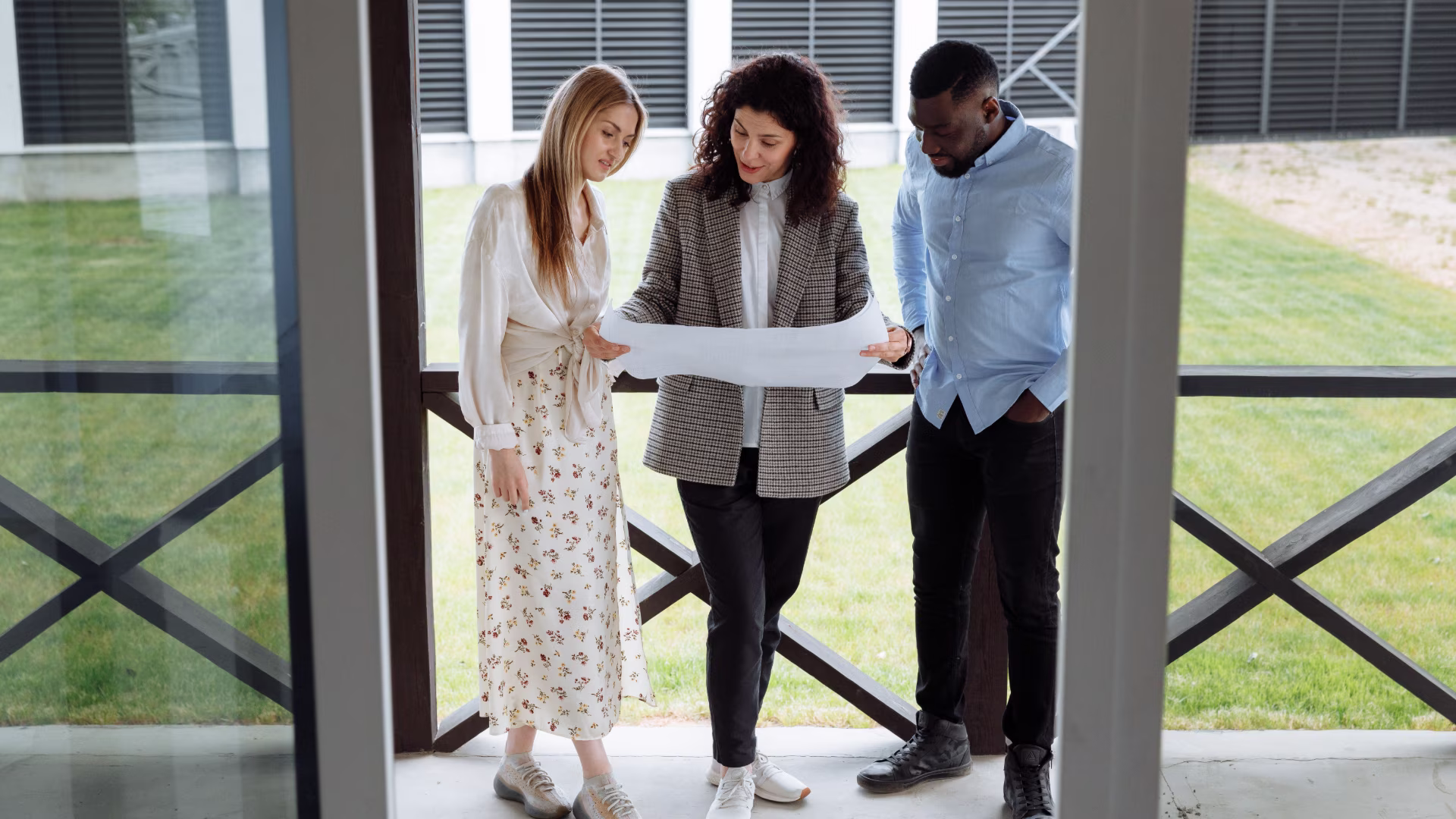 A leasing agent with two potential clients outside on a patio